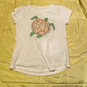 White t-shirt with a drawn turtle design on the front